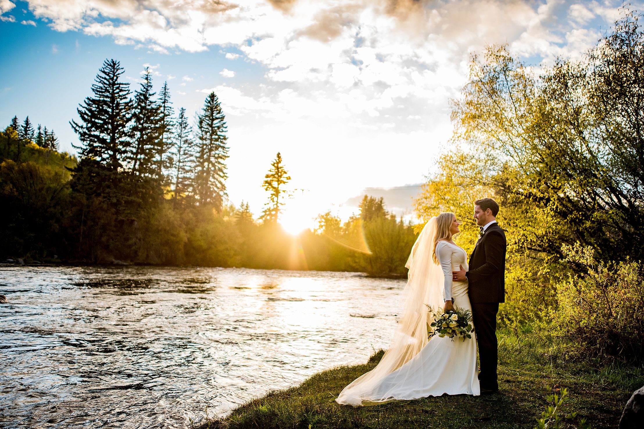 bride and groom hold on to each other as the golden sun shines on them