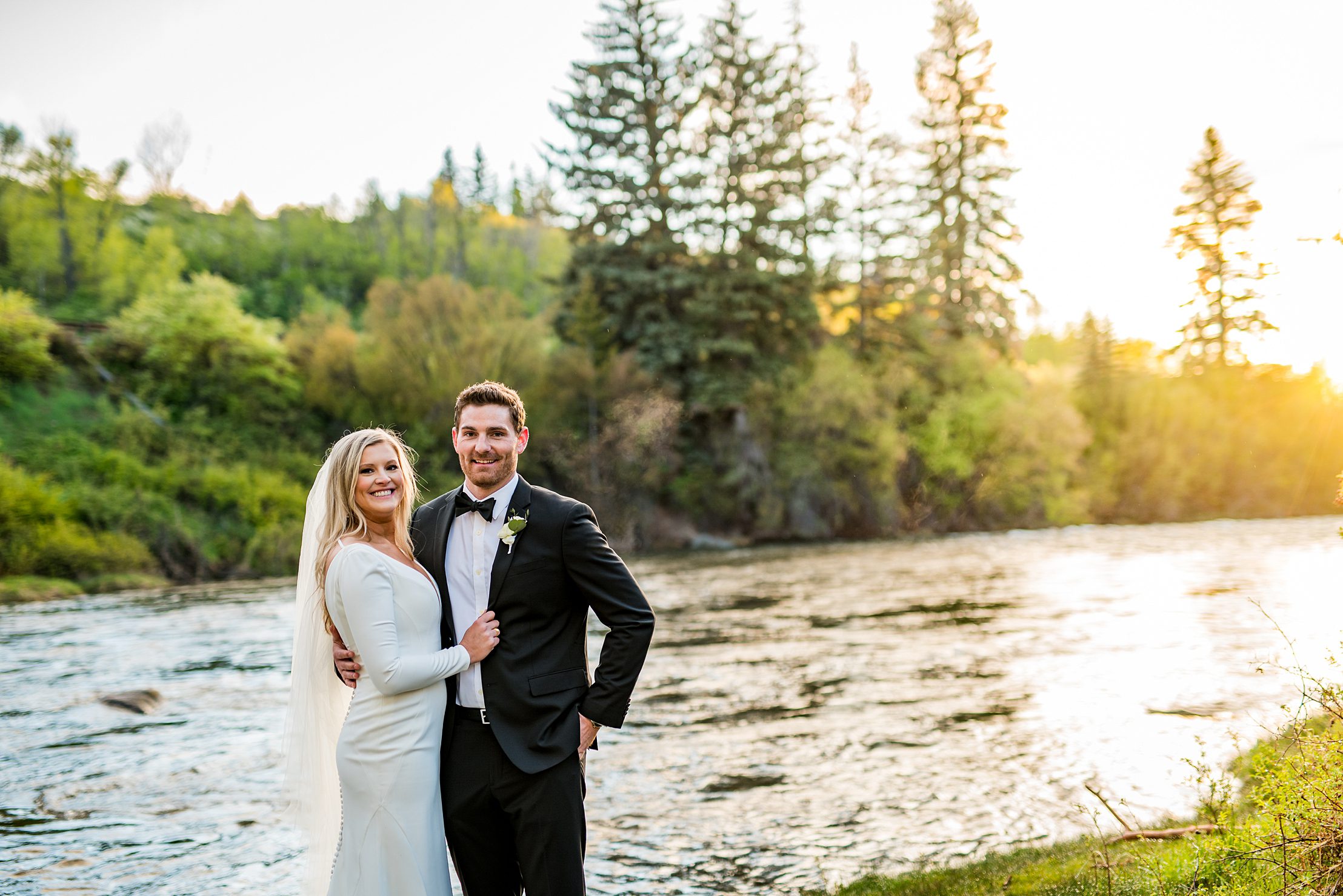 wedding couple looking at the camera with the river behind them in Vail