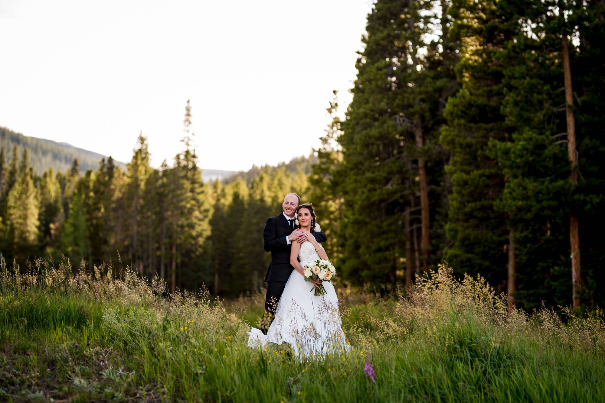 groom hugging his bride in the mountains of Colorado