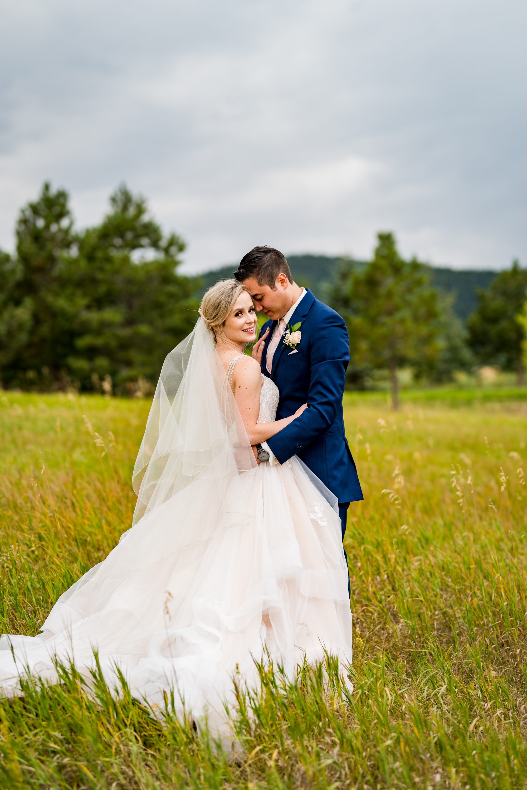 bride looking at the camera while hugging her husband