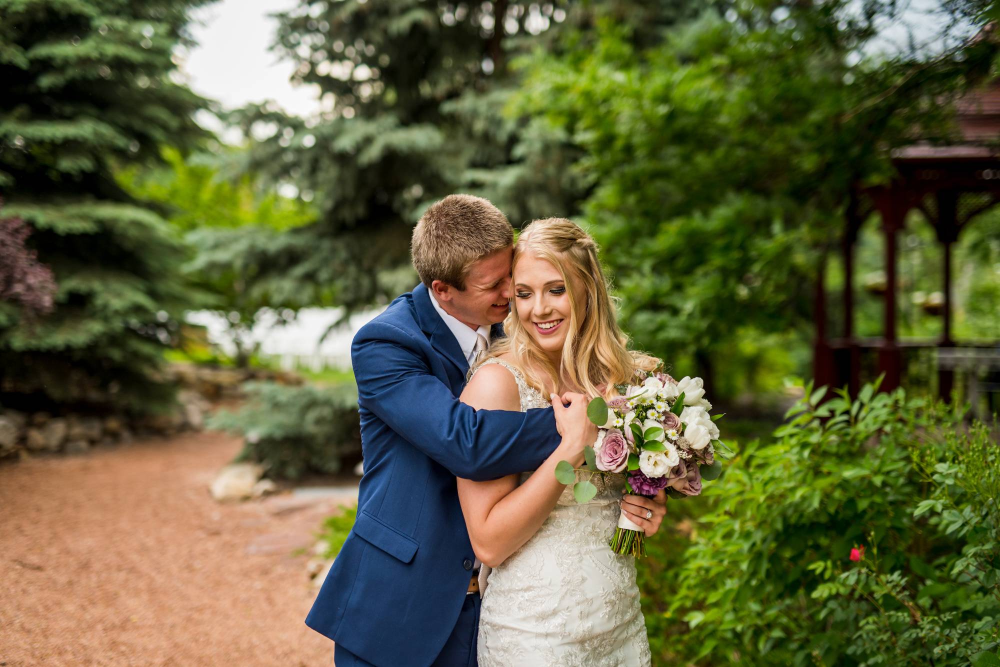 Denver groom hugging his bride with trees in the background