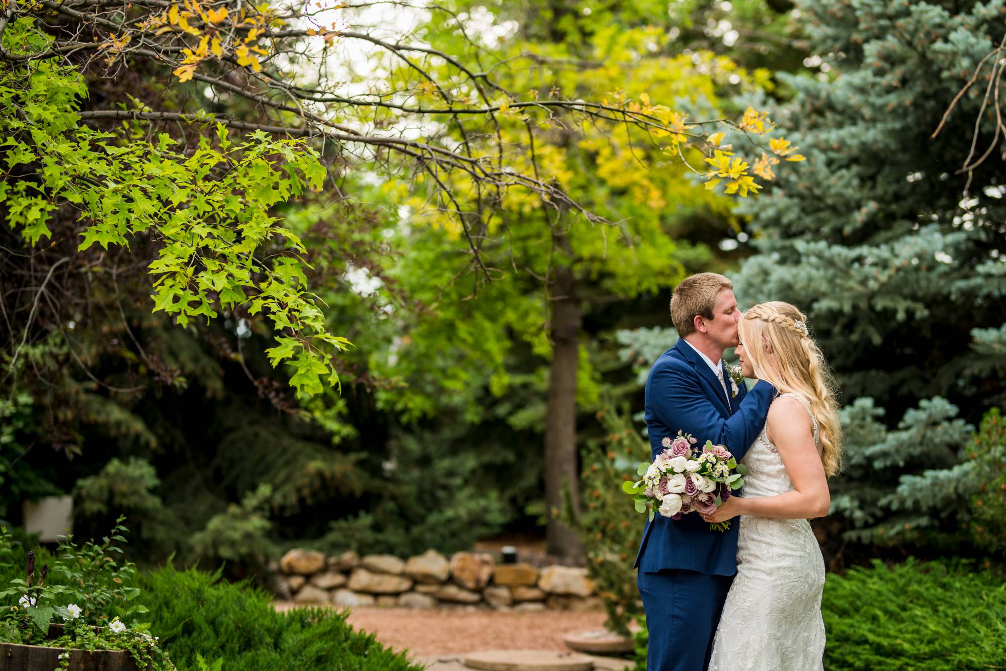 Colorado groom kissing the forehead of his bride at church ranch event center