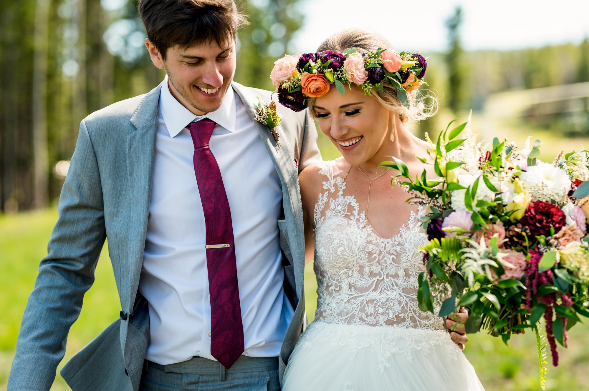 Colorado wedding couple walking and laughing through the field at Ten Mile Station