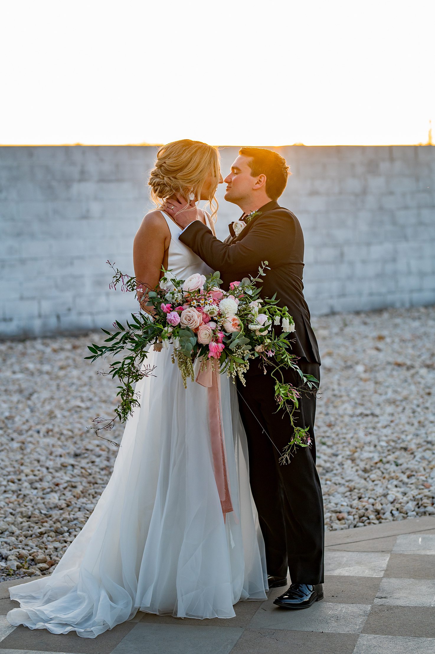 bride and groom kiss at sun sunset at a Texas wedding venue