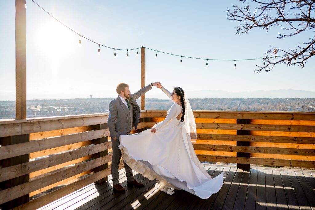 Colorado wedding photographer captures the perfect moment of a bride and groom dancing together at Brittany Hill in Denver, CO