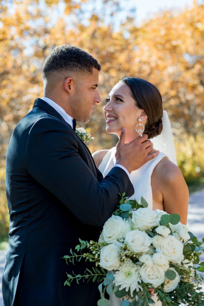 Bride and groom share an intimate and romantic moment surrounded by golden fall foliage at Spruce Mountain Ranch in Colorado. True-to-color wedding photography capturing natural beauty and emotion at a top Colorado wedding venue.