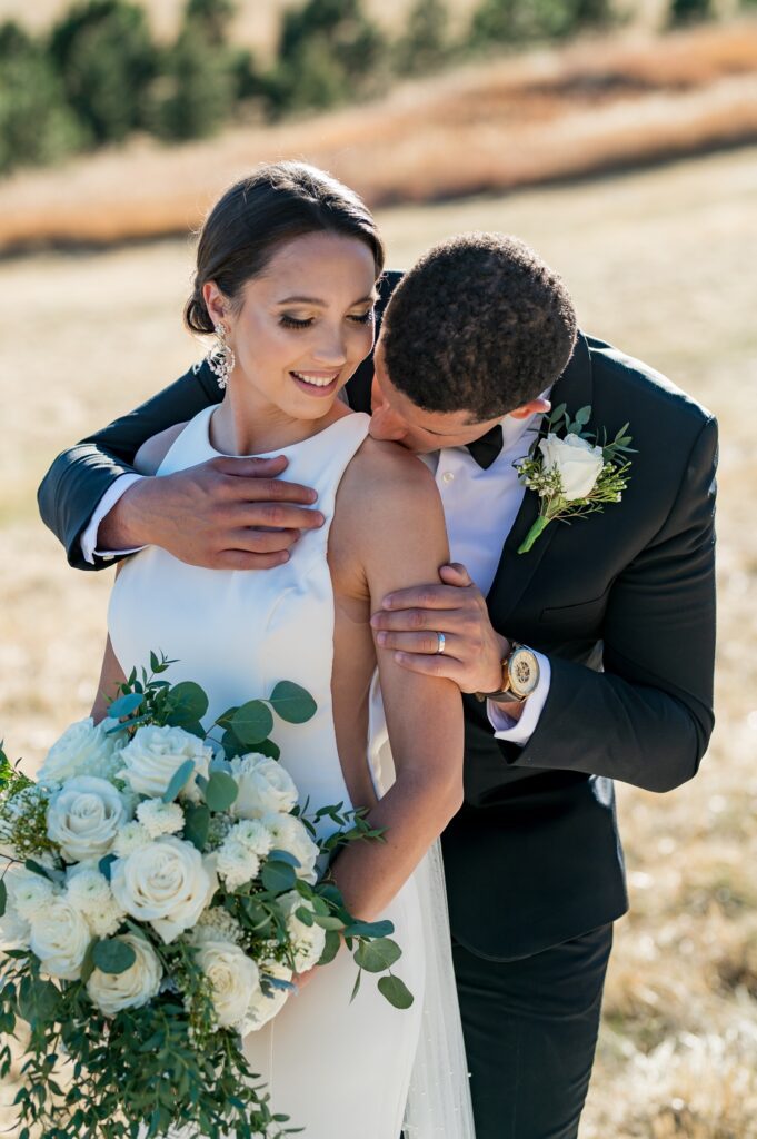 bride and groom at spruce mountain ranch have some time together in the field.