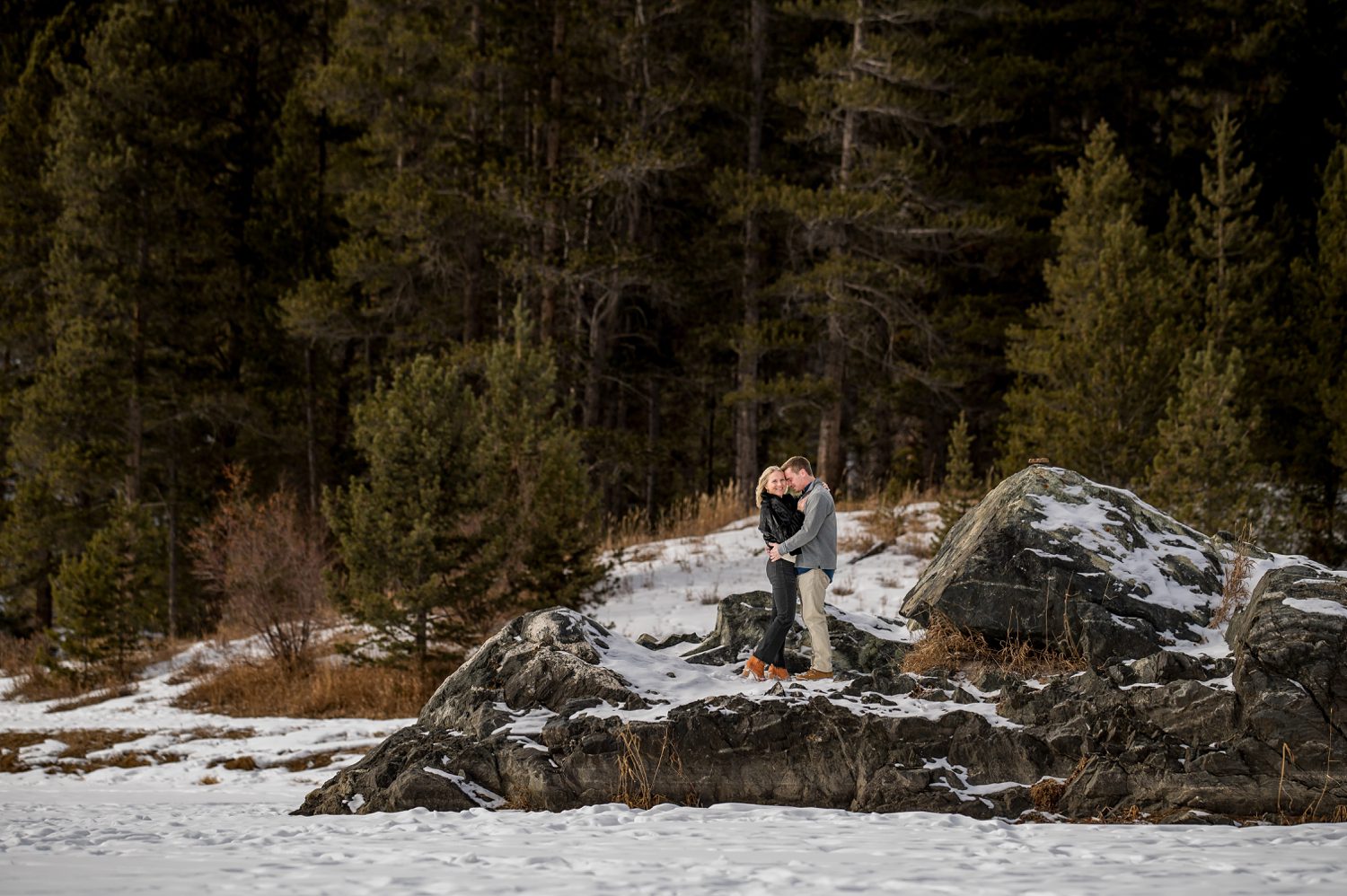 wedding couple on the rocks at Officers gulch pond hugging.