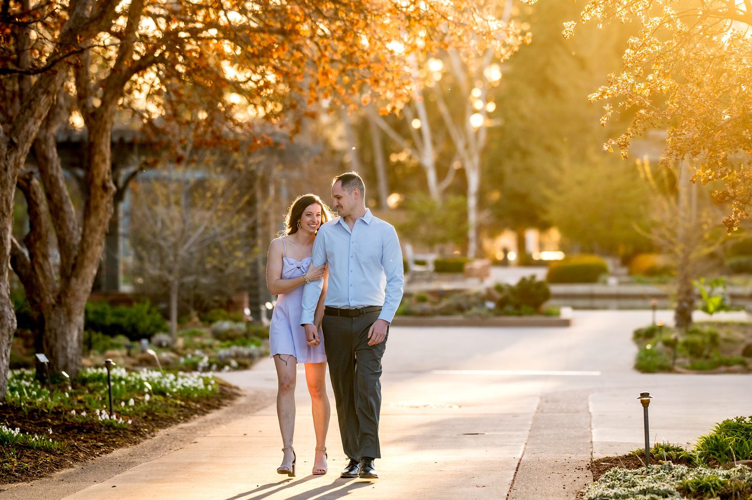wedding couple during their engagement session at Denver Botanic Gardens. The couple is walking through the garden.